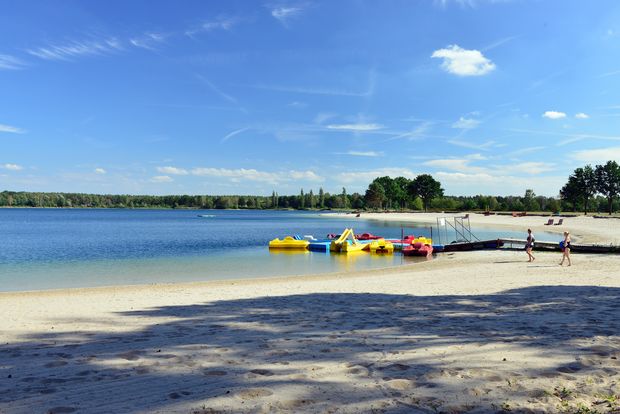 Bunte Tretboote im Tankumsee und Sandstrand.