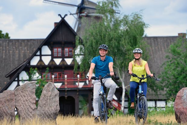Ein Mann und eine Frau mit auf zwei Fahrrädern vor Gifhorner Mühlenmuseum.