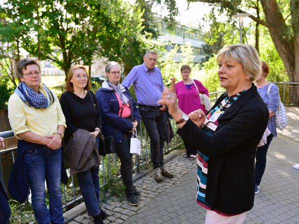 Eine Gästeführerin mit einer Gruppe.