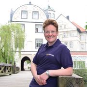 Dorette Basler Frau lehnt an der Holzbrück vor dem Gifhorner Welfenschloss.