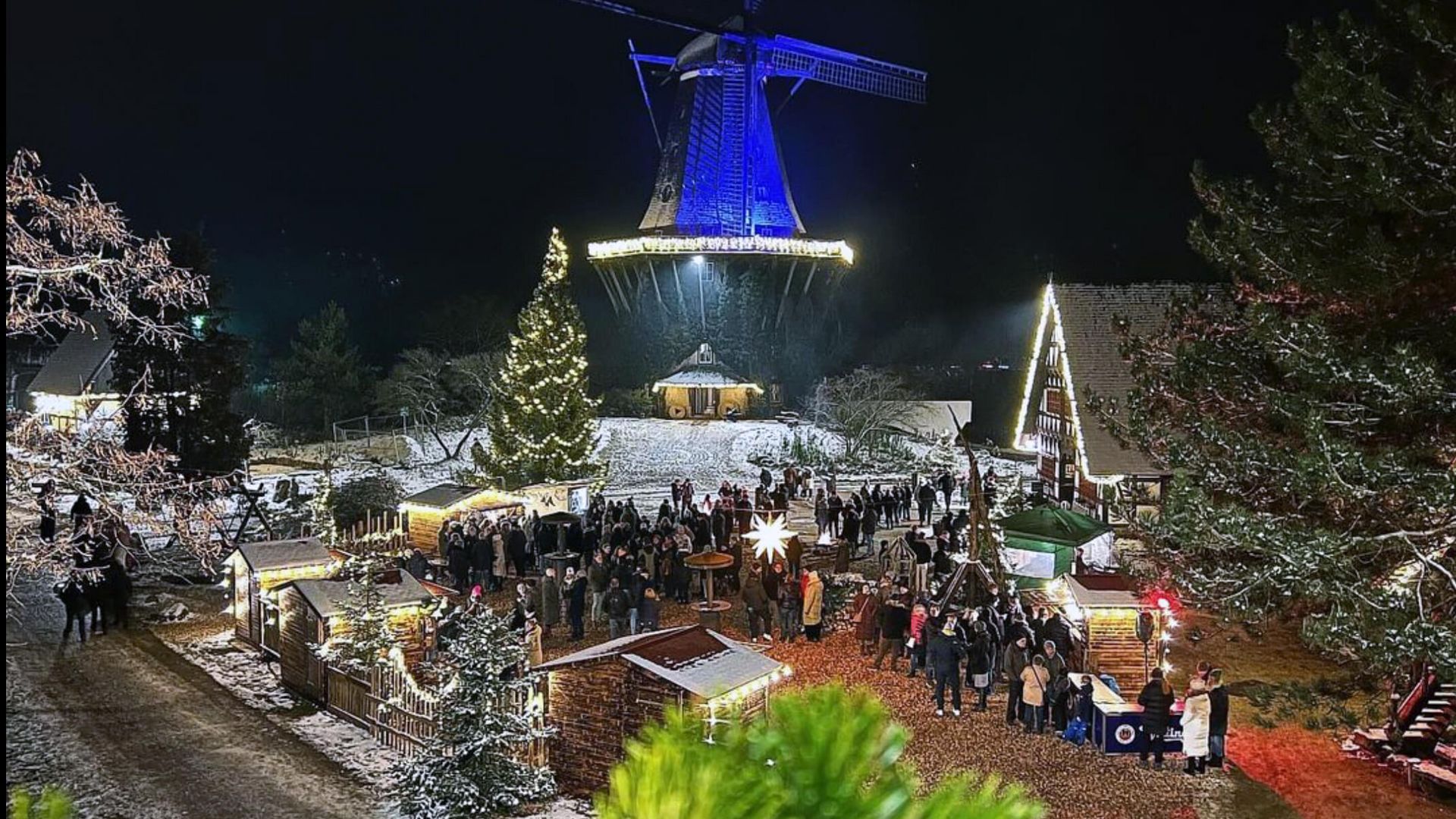 Mühlenweihnacht auf dem Dorfplatz Beleuchteter Dorfplatz mit Buden im Internationalen Mühlenmuseum mit beleuchteter Mühle.