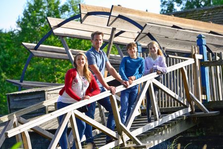 Ein Mann, eine Frau und zwei Kinder stehen vor der Wassermühle im Internationalen Mühlenmuseum in Gifhorn.