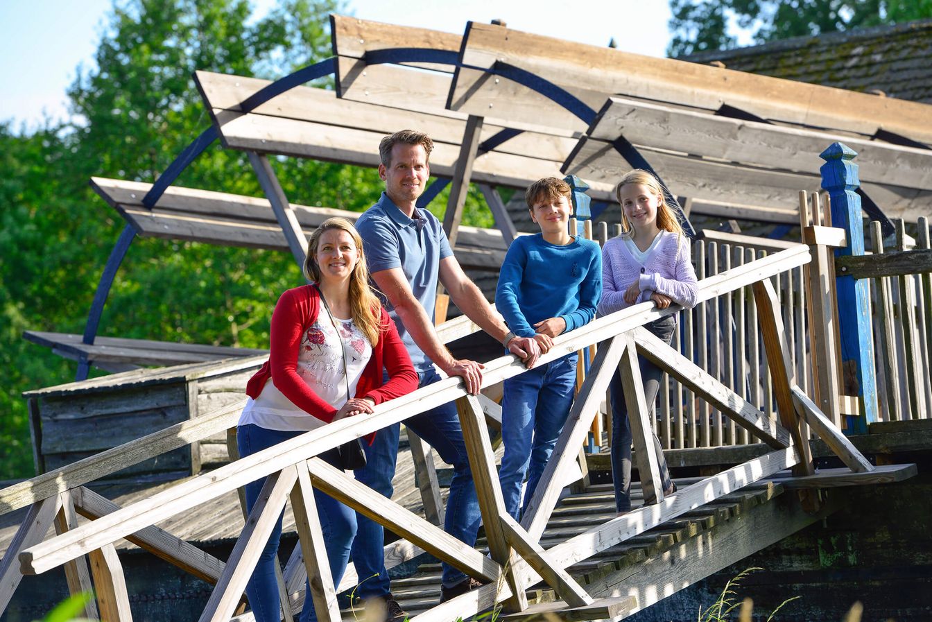 Ein Mann, eine Frau und zwei Kinder stehen vor der Wassermühle im Internationalen Mühlenmuseum in Gifhorn.