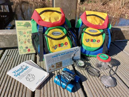 Zwei Kinderrucksack mit davor aufgebauten Inhalt.