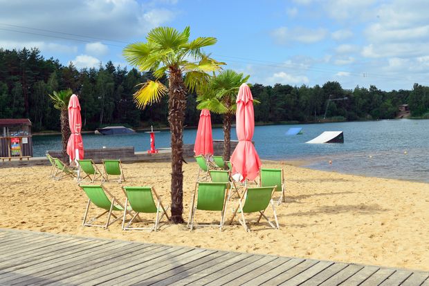 Strand mit Liegestühle und Wasser am Bernsteinsee bei Gifhorn.
