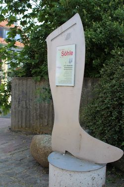 Übergroßer Schusterstiefel mit Beschreibungstafel in Wittingen.