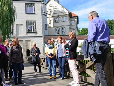 Eine Gästeführer mit einer Gruppe in der Gifhorner Altstadt.