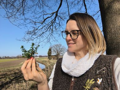 Gästeführerin Gitta Hemmerling mit einem Bündel Wiesenlabkraut in der Hand