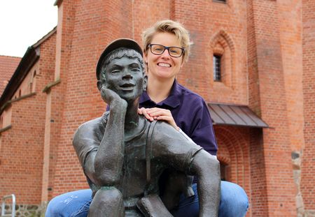Frau stützt sich auf Schusterjungen-Statur in Wittingen.